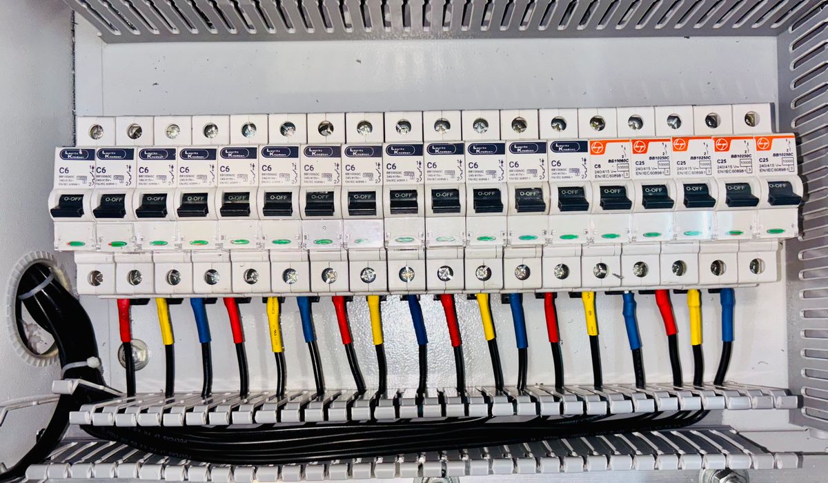 Row of labeled breakers with color coded wiring inside a panel